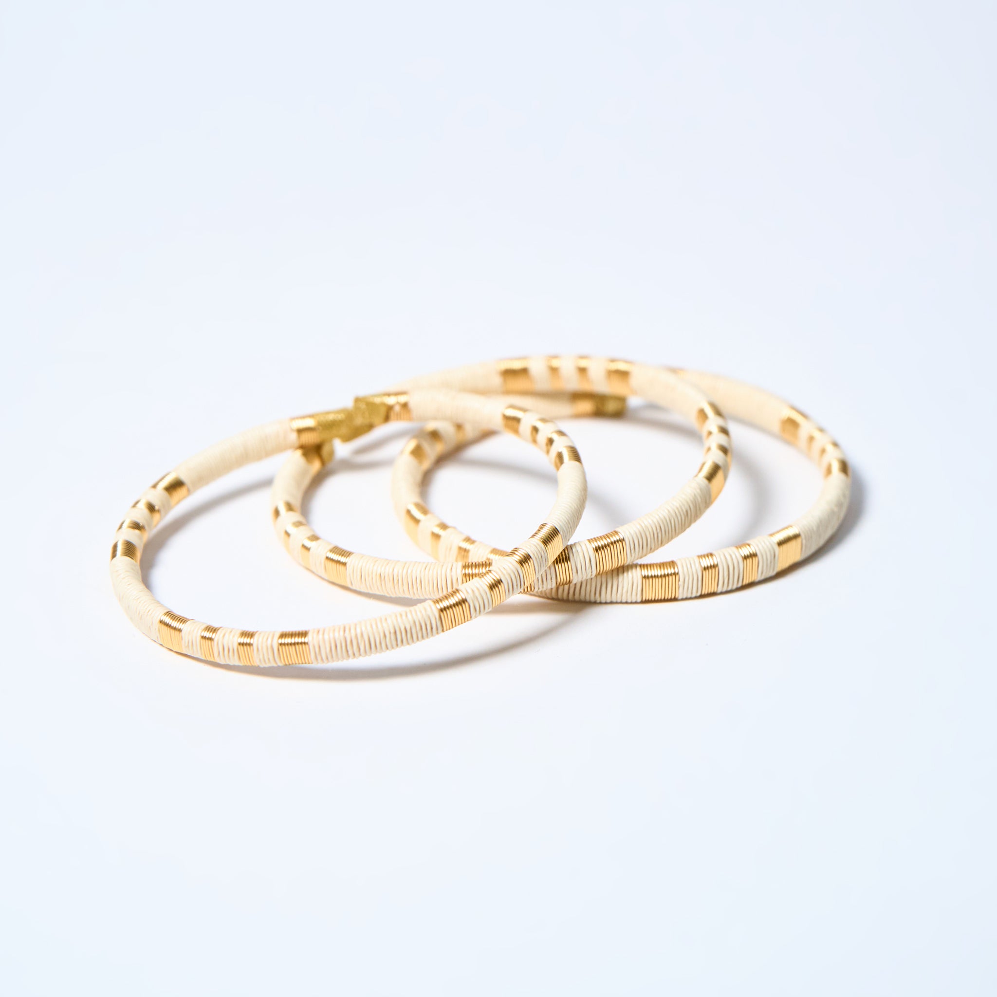 Set of handmade striped bracelets in cream and gold