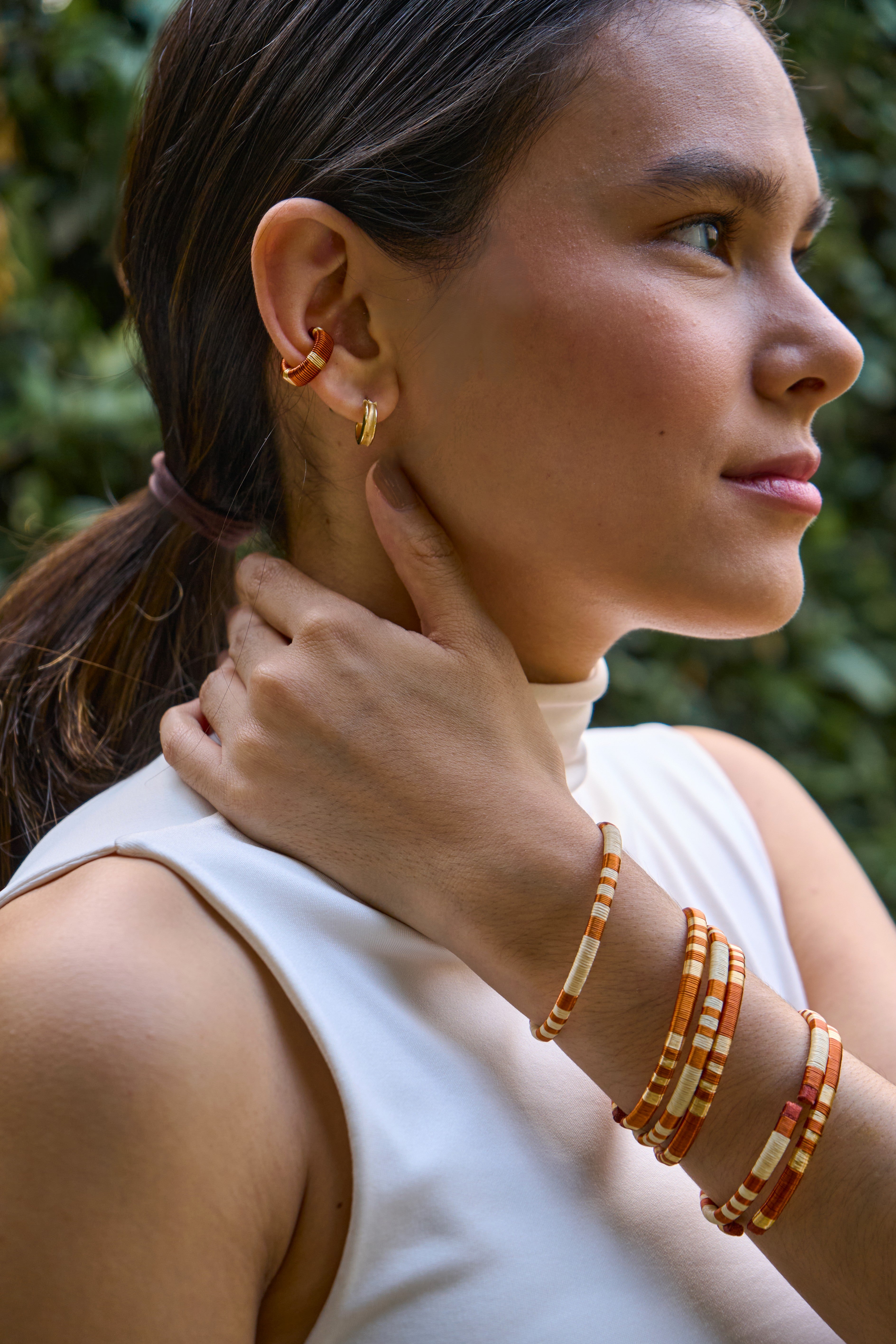 Woman wearing handmade earcuff and bracelets