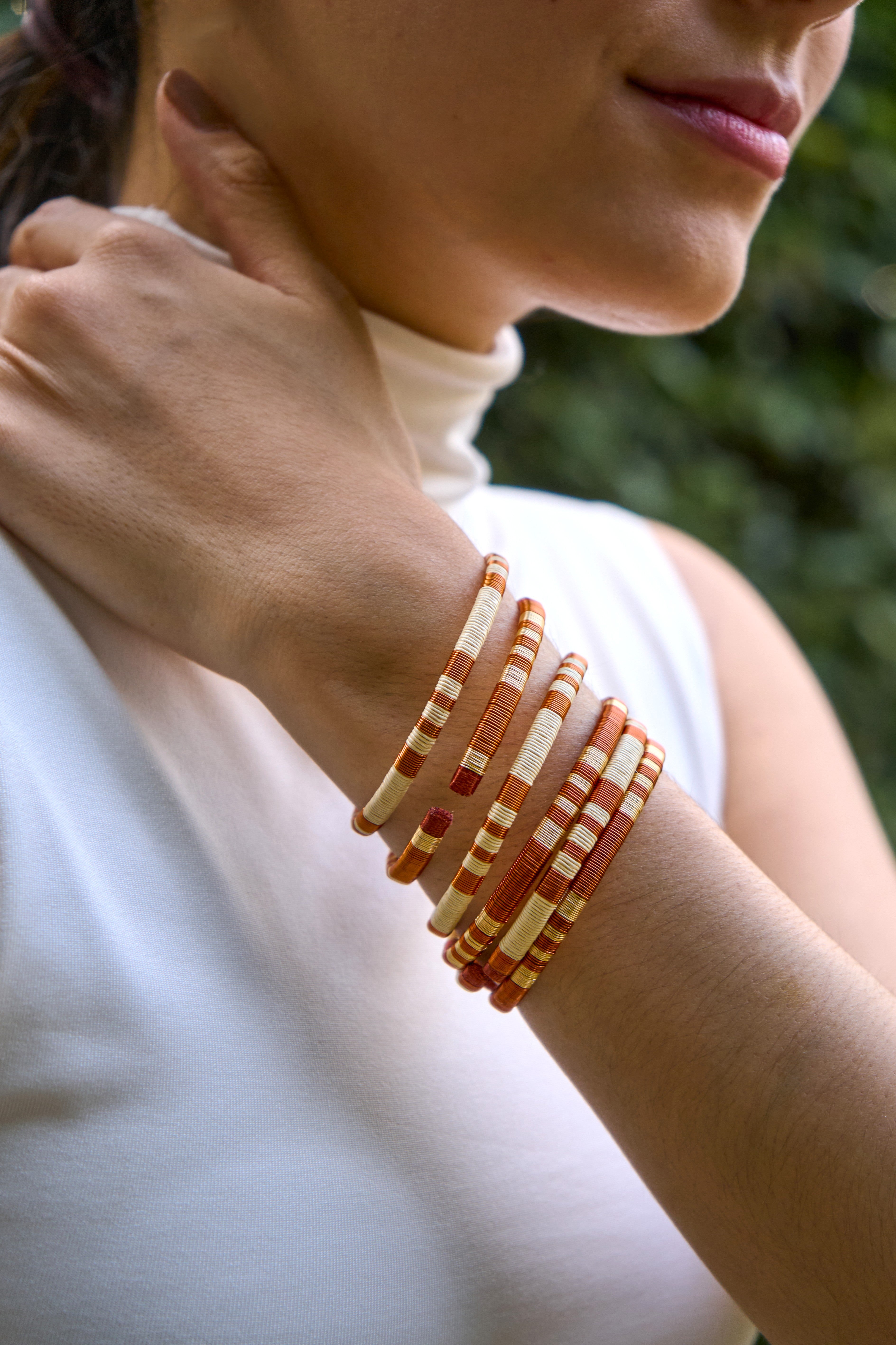 Close-up of a person wearing multiple handmade bracelets on their wrist