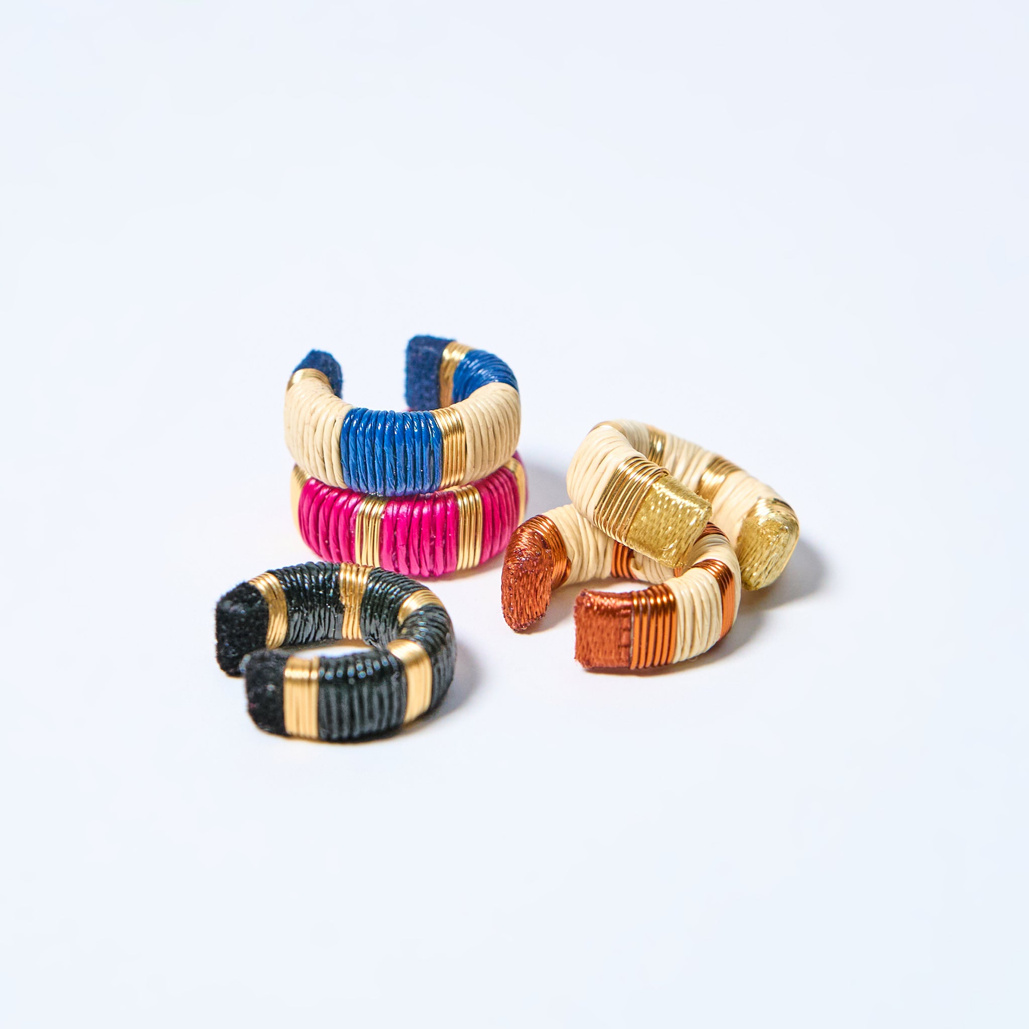 Set of colorful woven earcuffs on a light gray background